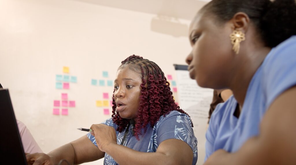 Omowunmi showing her colleague a data as a remote user researcher